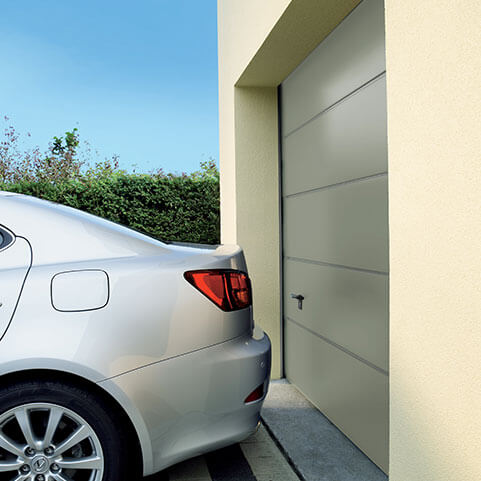 Car parked next to a garage door which has been made using high quality aluminium